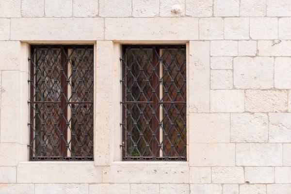 Dvě okna s mříží středověkém stylu v zámku — Stock fotografie