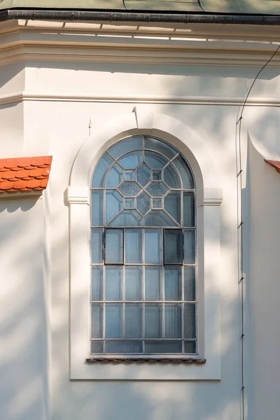 Une fenêtre avec un arc et un treillis, un mur blanc d'un bâtiment — Photo