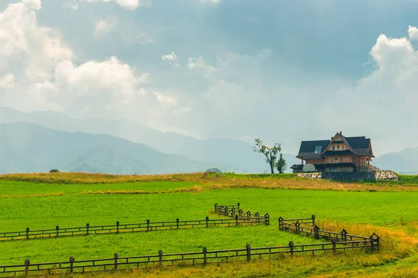 Villa a zöld gyepen, a hegyek a háttérben — Stock Fotó