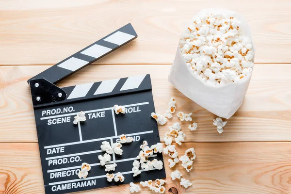 stock image video clapper and salted popcorn top view on wooden boards