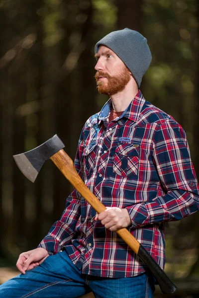 Retrato vertical de um lenhador com um machado nos fores de verão — Fotografia de Stock