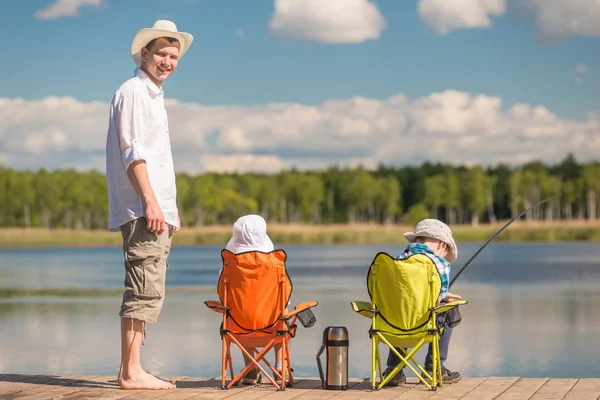 Человек и два сына на рыбалку, отец учит детей рыбачить — стоковое фото