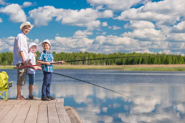 Los chicos y su padre pasan un día en un viaje de pesca en un sol — Foto de Stock