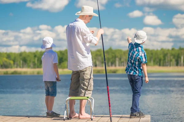 Chlapci s otcem o rybolovu na krásném místě u jezera — Stock fotografie