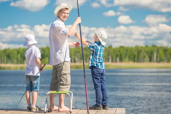 Padre feliz con los hijos en un viaje de pesca, retrato en longitud completa — Foto de Stock