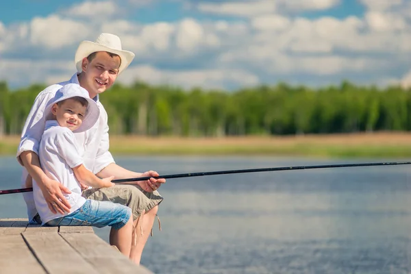 Hommes heureux avec une canne à pêche sur une jetée en bois tout en pêchant — Photo