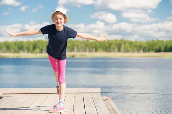 Retrato de uma menina de 10 anos em um cais perto de um lago — Fotografia de Stock