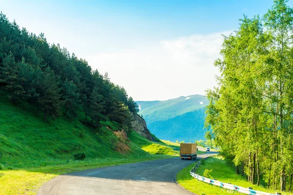 Mountain scenic road of the Caucasus and the truck with a load o — 图库照片