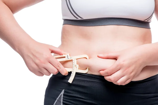 Mujer mide el nivel de grasa en el abdomen con una herramienta isola — Foto de Stock