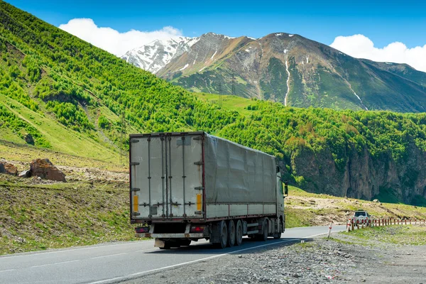 Carro cargado en las montañas en el camino militar georgiano — Foto de Stock
