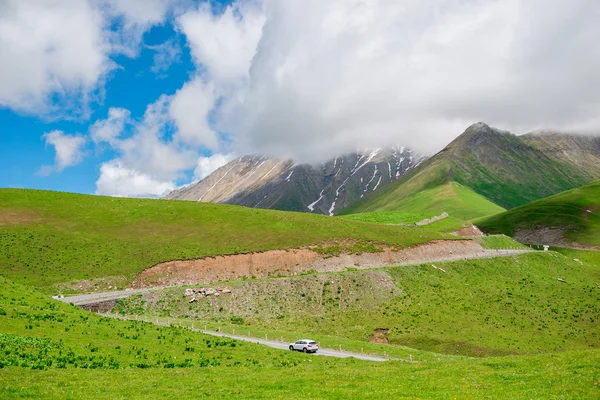 Un coche en la autopista militar de Georgia, una hermosa montaña roa — Foto de Stock