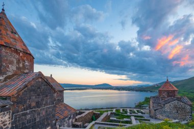 The buildings of Sevanavank monastery at sunset are a landmark of Armenia under a dramatic sky clipart
