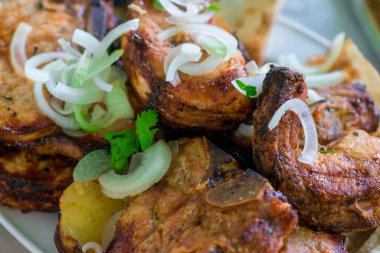 Soğanlı yakın plan domuz eti kebabı tabakta.