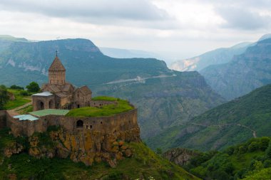 Ermenistan 'ın tarihi Tatev Manastırı bir uçurumun tepesindeki yüksek manzaralı dağların arka planına karşı