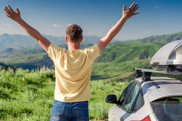 道路の旅行者は車の横に立って 美しい山々を見て喜びます — ストック写真