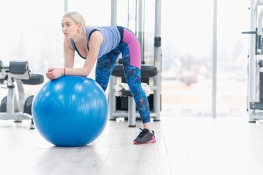 Genç kadın kız egzersiz egzersiz topu kullanarak spor salonunda