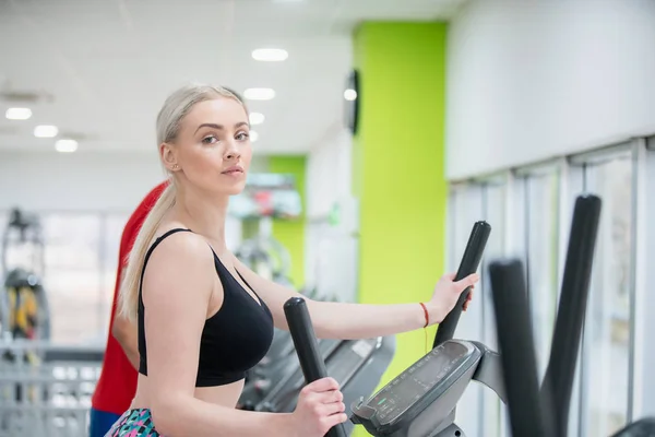 Fitness couple running doing cardio on treamill in fitness cente