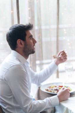 Genç adam restoranda sağlıklı yemek yeme