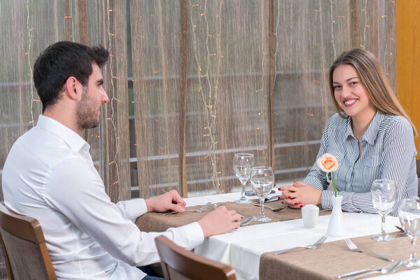 еда, праздники и люди - улыбающаяся пара ест основное блюдо в ресторане
