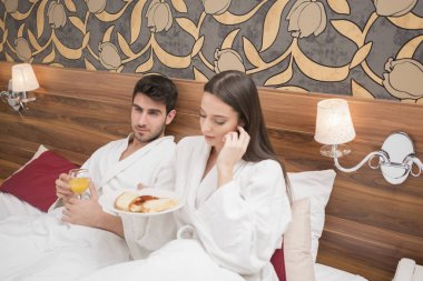 Beyaz cüppeli, yiyecek ve içecek zevk çekici genç Çift 