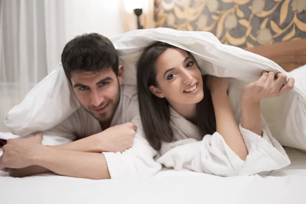 Hermosa joven pareja feliz disfrutando en la cama después del spa. Pareja i —  Fotos de Stock