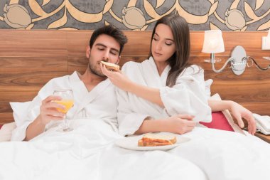 Beyaz cüppeli, yiyecek ve içecek zevk çekici genç Çift 