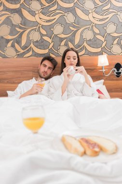 Beyaz cüppeli, yiyecek ve içecek zevk çekici genç Çift 