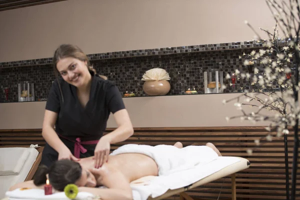 Spa woman. Female enjoying relaxing back massage in cosmetology spa centre. Body care, skin care, wellness, wellbeing, beauty treatment concept.