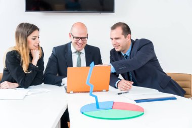 Üç ofisinde oturan ve iş planlama bir iş takımı. İş stratejisi yapmak dizüstü bilgisayar kullanarak. Başlangıç geliştirme.