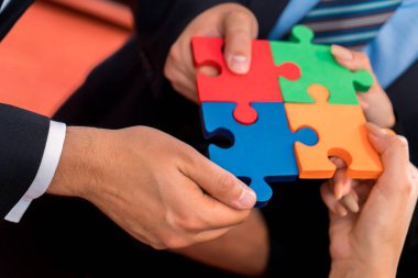 İş insanlar çözme parçalı bulmaca. Renkli puzzle parçaları elinde tutan takım