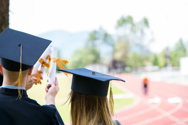 Grupo de estudantes de pós-graduação por trás. Estudantes titulares de diploma — Fotografia de Stock