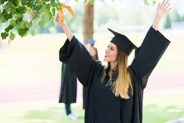 Abschluss: Studentin mit Diplom und Freunden im Rücken — Stockfoto