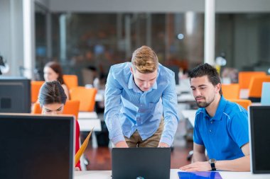 Grup içinde modern bir ofis toplantısı bir dizüstü bilgisayar ile yaratıcı insan. Konuşma yeni proje üzerinde rahat iş adamları.