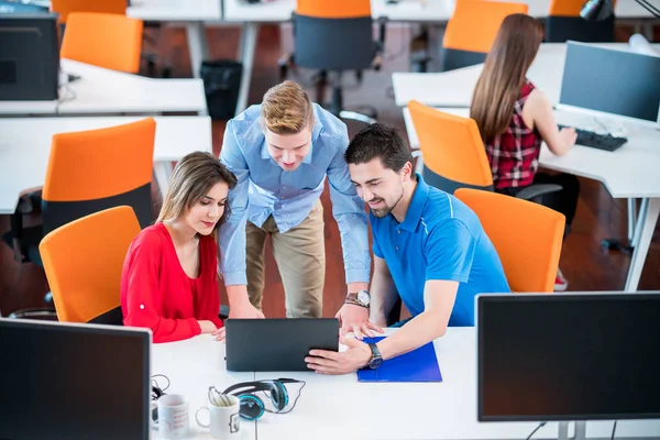 Grup içinde modern bir ofis toplantısı bir dizüstü bilgisayar ile yaratıcı insan. Konuşma yeni proje üzerinde rahat iş adamları.