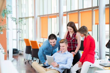 Girişim işi, genç yaratıcı insanlar grup ofis içi toplantılarında beyin fırtınası yapıyorlar ve fikir planları ve projeleri not etmek için dizüstü bilgisayar ve tablet bilgisayar kullanıyorlar