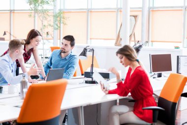 Girişim işi, genç yaratıcı insanlar grup ofis içi toplantılarında beyin fırtınası yapıyorlar ve fikir planları ve projeleri not etmek için dizüstü bilgisayar ve tablet bilgisayar kullanıyorlar