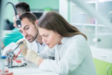 Genç takım diş teknisyenleri diş prostetics yapma. Süreç