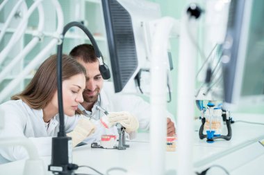 Genç takım diş teknisyenleri diş prostetics yapma. Süreç