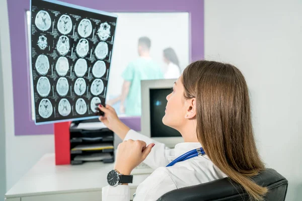 Doctora mirando una radiografía en su consultorio — Foto de Stock