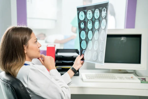 Doktorka se dívá na rentgen ve své kanceláři — Stock fotografie