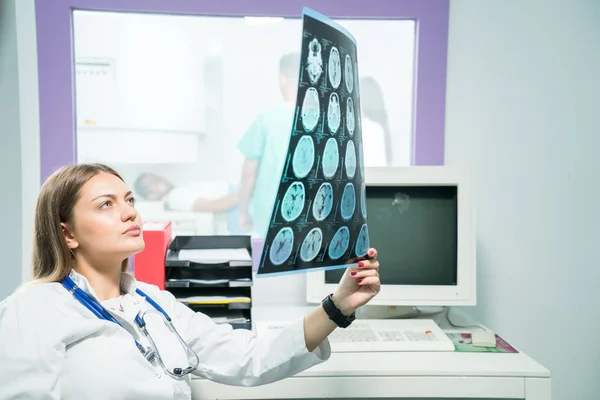 Doctora mirando una radiografía en su consultorio — Foto de Stock