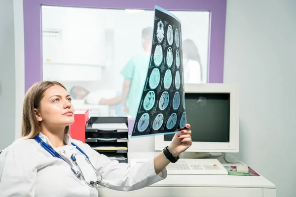 Doctora mirando una radiografía en su consultorio — Foto de Stock