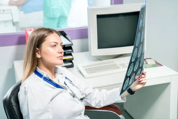Doktorka se dívá na rentgen ve své kanceláři — Stock fotografie