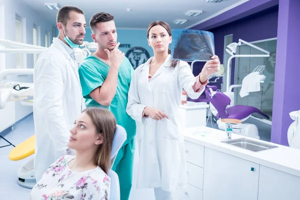 Equipo médico dental que examina y trabaja en la pati de mujeres jóvenes — Foto de Stock