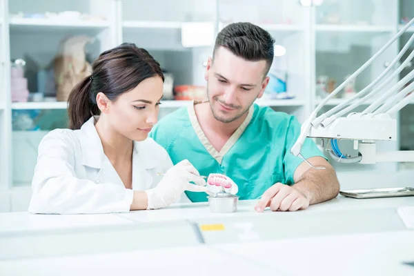 Equipo joven de técnicos dentales haciendo prótesis dental. Proces — Foto de Stock