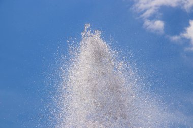 Mavi gökyüzüne karşı fışkıran fıskiye püskürtüleri. Geçmişi. Sparkli