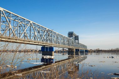 Arkhangelsk. Bahar akşamı. Severnaya Dvina nehrinde buz akıntısı. Dünyanın en kuzeydeki asma köprüsü.