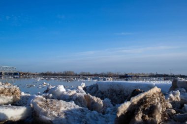 Arkhangelsk. Bahar akşamı. Severnaya Dvina nehrinde buz akıntısı. Dünyanın en kuzeydeki asma köprüsü.