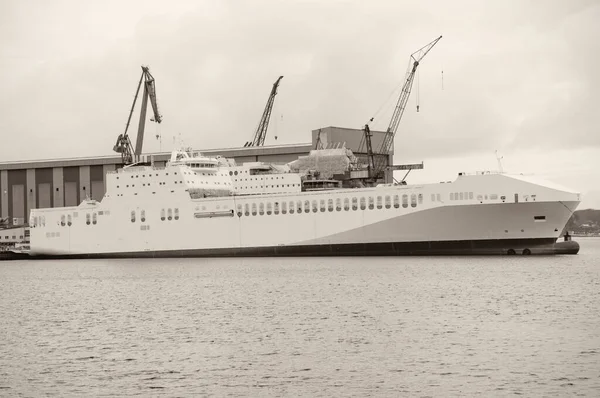 港内の貨物と旅客フェリー 背後の造船所 — ストック写真