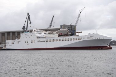 FLENSBURG. GERÇEK. 26 Ocak 2020 'de. Kargo ve yolcu feribotu limanda. Arkaplanda tersane.